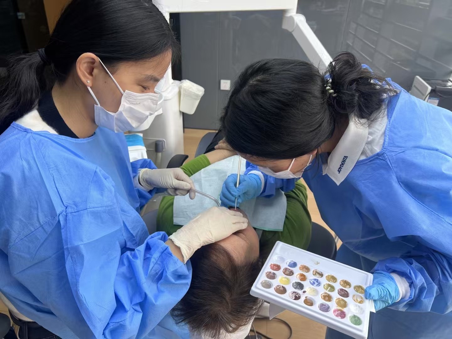 Blog công ty mới nhất về Các kỹ thuật viên sơn sắc tinh vi đang sơn răng của bệnh nhân